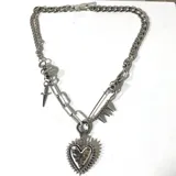 Collar de cadena plateada con dije de corazón con pinchos, detalles de espada y pin de gancho con pinchos.