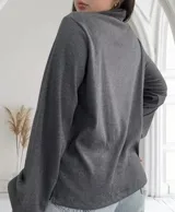 Blusa gris topo de tejido de punto acanalado, con cuello alto y mangas largas abullonadas.