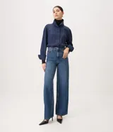 Pantalón wide leg de tiro alto confeccionado en jean de algodón, con pretina con pasacintos, cierre frontal con botón y cremallera, y bolsillos delanteros y traseros.