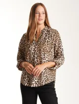 Blusa de gasa con estampado animal print en tonos beige, marrón y negro. Presenta cuello a la base, escote en V y mangas largas con presilla y botón para regular el largo.