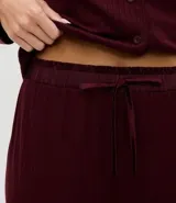 Pijama largo de dos piezas marca Lov, confeccionado en tejido rib de poliéster con elastano. La blusa es de manga larga estilo americano con cuello solapa y cierre frontal de botones. El pantalón es de corte recto con cintura satinada.