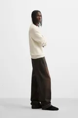 Jersey de punto de tacto suave con diseño de rayas horizontales anchas en color rosa claro y marrón oscuro. Presenta cuello redondo, manga larga y terminaciones en rib.