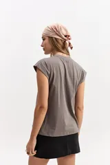 Musculosa oversize de algodón en color gris, con diseño sin mangas y estampado frontal con la palabra "MONACO" sobre franjas verticales naranjas y celestes.