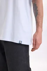 Remera celeste de manga corta y corte oversize, con estampa grande en la espalda que incluye un diseño abstracto de sol amarillo y textos negros.
