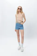 Top cropped sin mangas color beige, ajustado al cuerpo, con diseño cruzado asimétrico en la parte delantera.