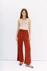 Pantalón palazzo tiro alto color terracota, con cintura elastizada y bolsillos diagonales. Corte relajado y largo al tobillo.