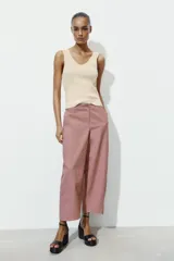 Pantalón de tiro alto con diseño tipo ballon, bolsillos laterales ocultos en costura y cierre frontal con cremallera y botón.