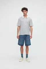 Remera polo de manga corta con diseño de rayas horizontales, cuello liso contratono y tapeta con botones. Confeccionada en tejido de jersey de algodón con textura suave y tajos laterales en el dobladillo.