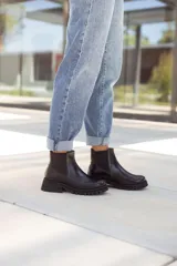 Botas tipo Chelsea de cuero negro con paneles elásticos laterales y suela track de goma gruesa. Confeccionadas a mano en Uruguay.