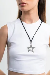 Collar con cordón negro y dije de estrella plateada con diseño calado.