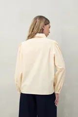 Camisa blanca de mangas 3/4 abullonadas con bordado floral en el frente.