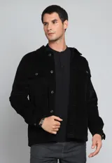 Sobrecamisa negra de pana con cuello clásico, cierre frontal con botones, dos bolsillos de parche con solapa en el pecho y puños abotonados.