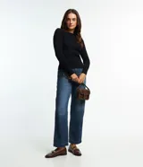 Blusa de punto de manga larga con cuello bote y textura acanalada vertical. Presenta un diseño ajustado al cuerpo, confeccionada en una mezcla de viscosa y poliamida.