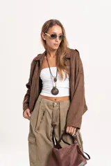 Chaqueta tipo bomber de gamuza color marrón, con diseño oversize, mangas amplias y cierre frontal.