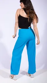 Pantalón de vestir celeste con pinzas, tiro alto y corte recto.