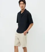 Bermuda masculina de corte slim y estilo sastre, confeccionada en sarga de algodón. Presenta cintura con trabillas, cierre tradicional y bolsillos laterales.