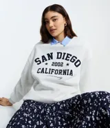 Buzo gris melange de cuello redondo con estampa frontal estilo universitario "SAN DIEGO 2002 CALIFORNIA", confeccionado en algodón con felpa y detalles acanalados en puños y ruedo.