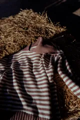 Sweater de tejido de punto con diseño a rayas horizontales en color marrón y blanco, cuello con solapa y mangas largas.