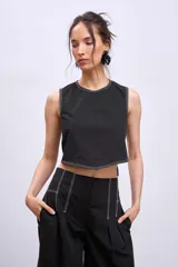 Blusa crop top negra sin mangas con cuello redondo y pespuntes blancos contrastantes.