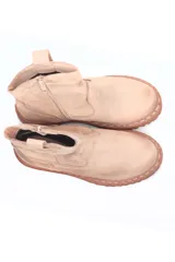 Botín de cuero color beige con suela marrón de goma.