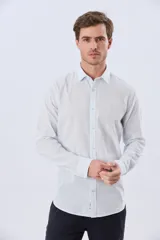 Camisa de lino a rayas finas en tonos beige y blanco, de manga larga con puños vueltos, cuello camisero y cierre frontal de botones. Cuenta con un pequeño logo bordado en el pecho.