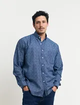 Camisa azul con estampado de lunares blancos, de manga larga y corte clásico.