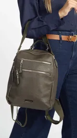 Mochila color beige de símil cuero con doble apertura superior con cierre. Incluye dos bolsillos al frente con cierres metálicos, asa rígida de mano y correa de galón. En la espalda correas de galón regulables.
