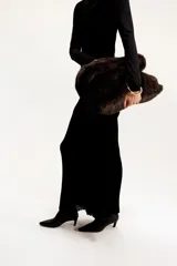 Botines de cuero negro con caña elástica, punta fina y taco fino de altura media.