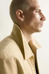Cazadora regular fit de color beige, confeccionada en mezcla de algodón y lyocell. Cuenta con cuello camisero, cierre frontal de cremallera, bolsillos de plastrón en la cadera, mangas largas con puños elásticos y bajo con ajuste elástico.