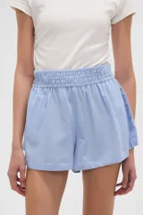 Short de calce alto y corte holgado, confeccionado en tela de viscosa color celeste, con cintura elástica fruncida.