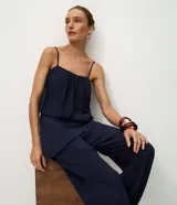 Pantalón modelo aladim confeccionado en jacquard de viscosa, con diseño floral en relieve, cintura elástica y superposición asimétrica en el delantero que forma un canesú redondeado.