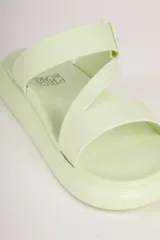 Sandalias de plataforma baja color verde claro, con tiras anchas cruzadas en el empeine y suela de goma moldeada.