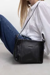 Cartera bandolera de cuero color negro, de diseño estructurado con panel central liso y laterales con textura efecto croco. Cuenta con correas ajustables y costuras a contratono.