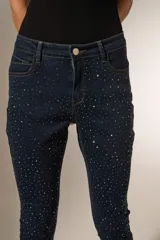 Pantalón jean negro skinny con strass y calce medio.