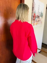 Camisa de manga larga color rojo ciruela, con cuello clásico y cierre frontal de botones de nácar.