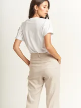 Remera blanca de corte oversized con estampado de figuras femeninas abstractas en colores rojo, marrón, celeste y lila.