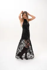 Vestido largo negro de encaje con cuello halter y espalda descubierta, con forro corto y falda translúcida.
