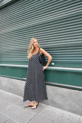 Vestido largo de crepe con estampado de lunares negros sobre fondo blanco. Presenta un diseño de corte holgado con breteles finos y escote redondeado.