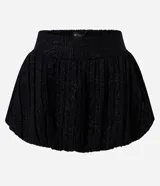 Minifalda negra de jacquard con tiro alto, cintura estructurada y corte baloné voluminoso.