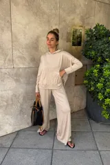 Canguro holgado color beige, con capucha y bolsillo canguro frontal.