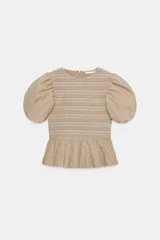 Top color beige con cuerpo de nido de abeja elástico con bordados a contraste, mangas cortas abullonadas y detalle de volante en el bajo. Cuenta con cierre en la espalda con cremallera oculta.