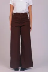 Pantalón de corte wide leg confeccionado en pana acanalada color marrón chocolate. Presenta tiro alto, cierre frontal con botón y bolsillos laterales.