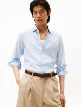Camisa celeste de algodón regenerativo con tejido de sarga, corte regular, cuello camisero clásico, cierre con botones, puños abotonados y logo de Tommy Hilfiger bordado en el pecho.