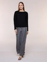 Buzo de punto fino color gris, de calce relajado, escote redondo amplio y canesú con textura acanalada. Cuenta con apliques de tachas metálicas doradas en la línea del hombro, mangas largas de hombro caído y puños y ruedo acanalados.