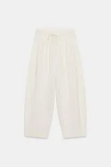 Pantalón balloon de algodón color crudo, con tiro medio, cintura elástica ajustable con cordón y bolsillos laterales.