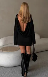 Vestido corto de manga larga en color negro, con diseño ajustado y detalle de fruncido en la zona de la cintura y cadera.