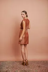 Vestido corto de jersey metalizado color cobre, sin mangas, con escote en V cruzado y falda recta.