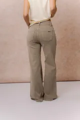 Pantalón de jean color arena con silueta wide leg, tiro medio-alto y costuras verticales delanteras que estilizan la figura. Cuenta con bolsillos funcionales y cierre frontal con doble botón.