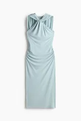 Vestido midi celeste de punto suave, sin mangas y con escote halter con detalle de nudo y fruncidos al frente. Cuenta con costuras laterales fruncidas que generan un efecto drapeado.