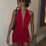 Vestido corto de color rojo, con escote halter pronunciado en V, tiras cruzadas para atar al frente y diseño drapeado ajustado.